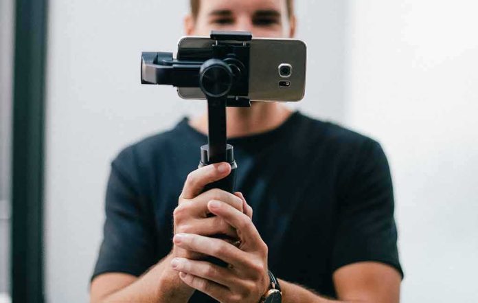 Person holding a smartphone on a handheld gimbal