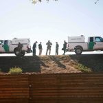 NEWS CREW GETS STUCK IN THE DESERT — So Did The Rescuers Border patrol agents stand between two trucks on a ridge