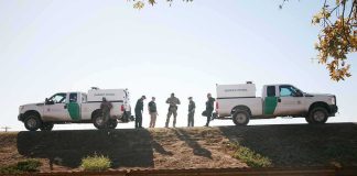 NEWS CREW GETS STUCK IN THE DESERT — So Did The Rescuers Border patrol agents stand between two trucks on a ridge