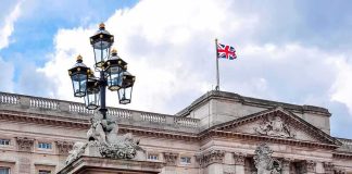 Buckingham Palace facade with Union Jack flag and ornate gate