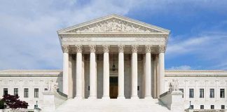 SUPREME COURT Packing Is Back — And He Said It On National TV Front view of the Supreme Court building with large columns and steps under a blue sky