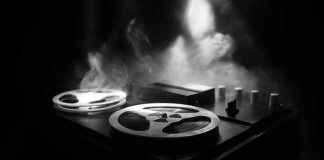 Reel-to-reel tape recorder in moody smoke-lit scene