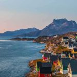 Colorful coastal town with mountains and sea at sunset