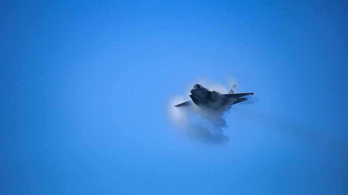 shutterstock_1542320999 fighter jet creating vapor cone in blue sky