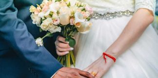 Couple's hands with wedding rings and bouquet