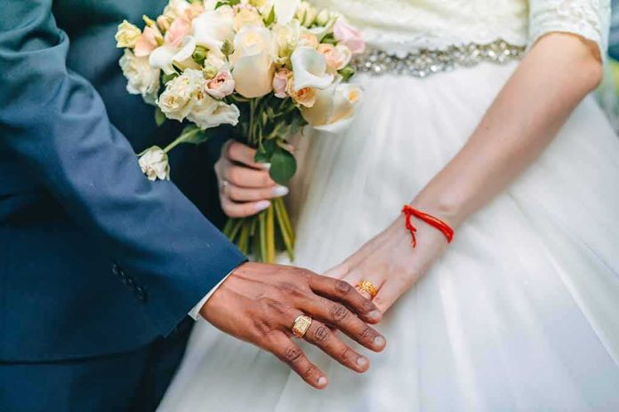 Couple's hands with wedding rings and bouquet