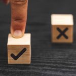 finger pressing wooden block with check mark