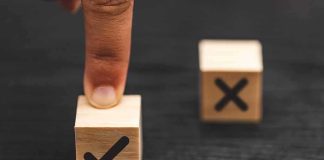 finger pressing wooden block with check mark