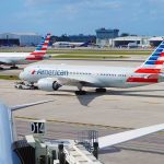 American Airlines jets taxi at a busy airport apron