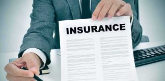 Your Name Might Be On An Insurance Plan You Never BOUGHT Person in suit holding an insurance document and a pen