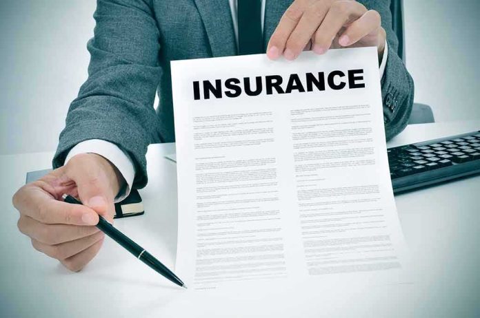 Person in suit holding an insurance document and a pen