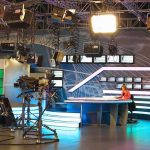 News studio with anchor at desk and cameras