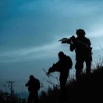 Trump-Tinged Twist In Colombia Silhouetted soldiers patrolling a hillside at dusk
