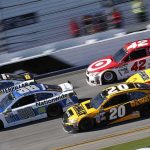Racing World Stunned: Kyle Busch Dies at 41 Stock cars racing side by side on a banked track