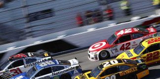 Stock cars racing side by side on a banked track