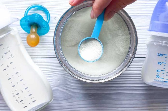 Baby formula powder in a can with a blue scoop