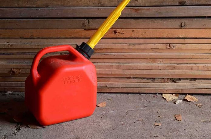 Red gasoline can with yellow spout on a garage floor