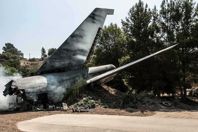 Wrecked airplane tail section beside a road