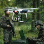 Cuban Drones Target U.S.? Hidden Threat Exposed quadcopter drone hovering near soldiers in a forest