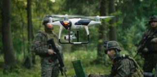 quadcopter drone hovering near soldiers in a forest