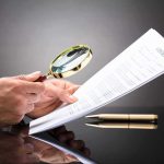 Trump Prosecutor’s CREEPY Files Reach WAY Past MAGA Hands holding magnifying glass over contract document