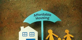 Paper cutouts of house and family under umbrella labeled affordable housing