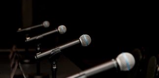 Democrat Candidate DENIED His Own VERIFIED Words Row of microphones on stands at a panel table
