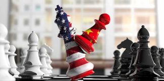 Chess pieces with US and China flag designs colliding on a board