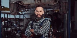 Trump RESCUES Mechanics From A ROTTEN Double Standard Auto mechanic standing with arms crossed in a garage