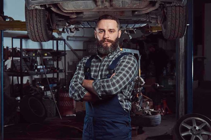 shutterstock_1079880173 Auto mechanic standing with arms crossed in a garage