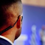 SHOCKING — DOJ Probes UNEXPECTED Stadium Ejections Security guard with earpiece watching a blurred event stage