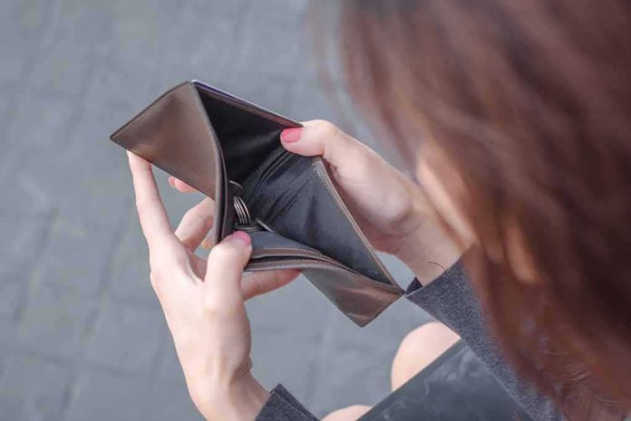 shutterstock_1161330046 Hands holding an open empty wallet