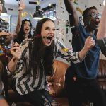 The Midterm Curse — What Are The ODDS The GOP Can Beat It? Group of friends cheering indoors with confetti flying