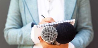 Journalist holding microphones and notepad