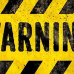 warning sign with yellow and black hazard stripes