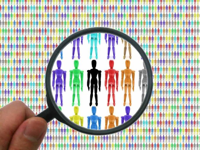 Magnifying glass focusing on colorful wooden mannequins