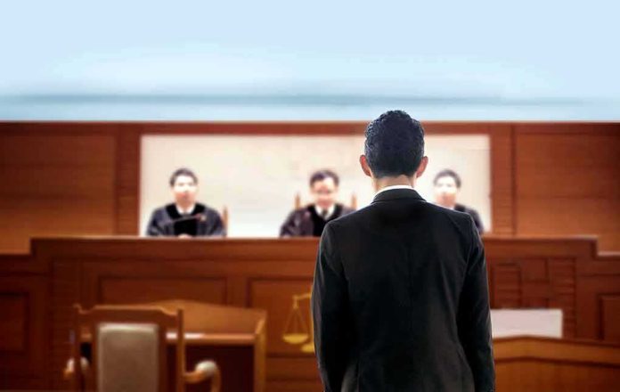 man in suit facing judges in a courtroom