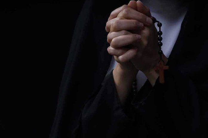 Hands clasped in prayer holding a rosary