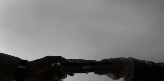 Silhouetted hands exchanging a stack of cash