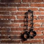 Iron shackles hanging on a brick wall