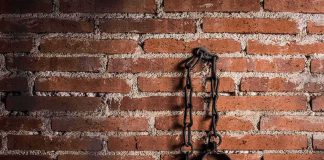 Iron shackles hanging on a brick wall