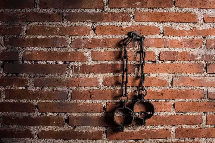 Iron shackles hanging on a brick wall