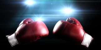 Two red boxing gloves facing each other with dramatic lighting