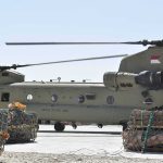 Chinook military helicopter on tarmac with cargo pallets