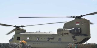 Chinook military helicopter on tarmac with cargo pallets