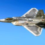 Stealth fighter jet in flight against a clear blue sky