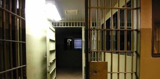 Prison corridor with open barred cell doors