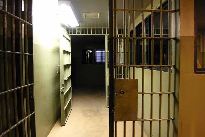 Prison corridor with open barred cell doors