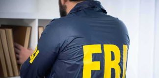 FBI agent searching a bookshelf