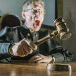 Judge slamming gavel on a wooden block